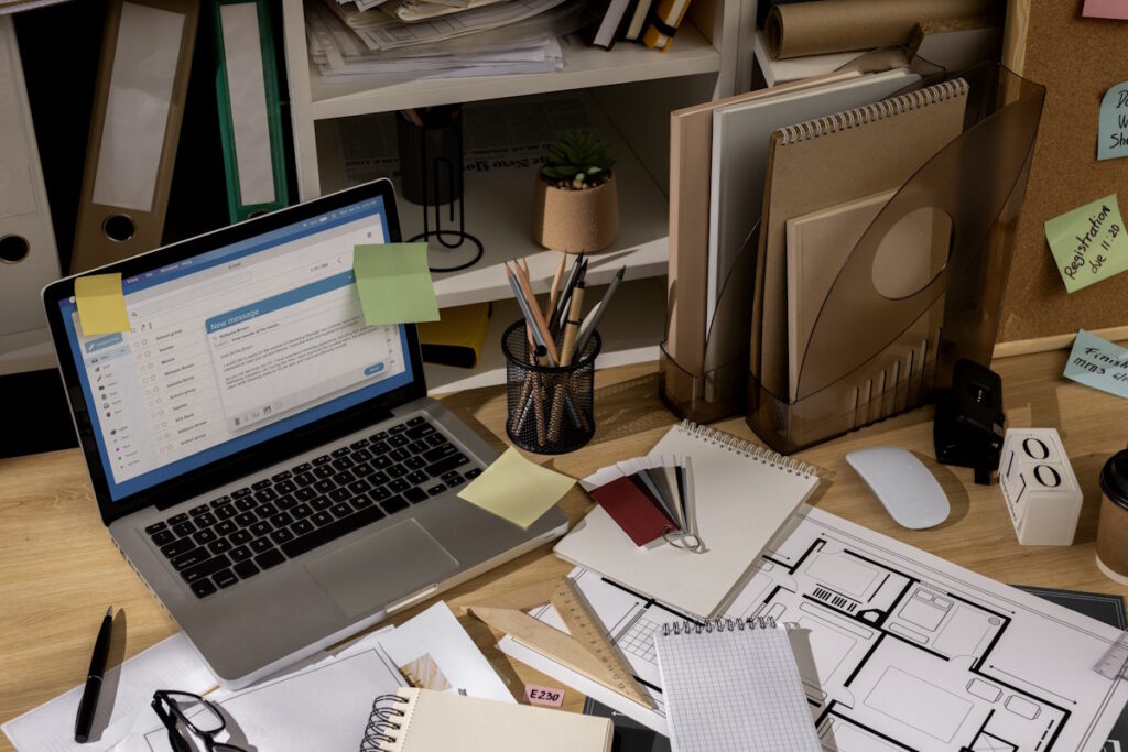 A desk scene showing invoices, laptop, and organised admin flow
